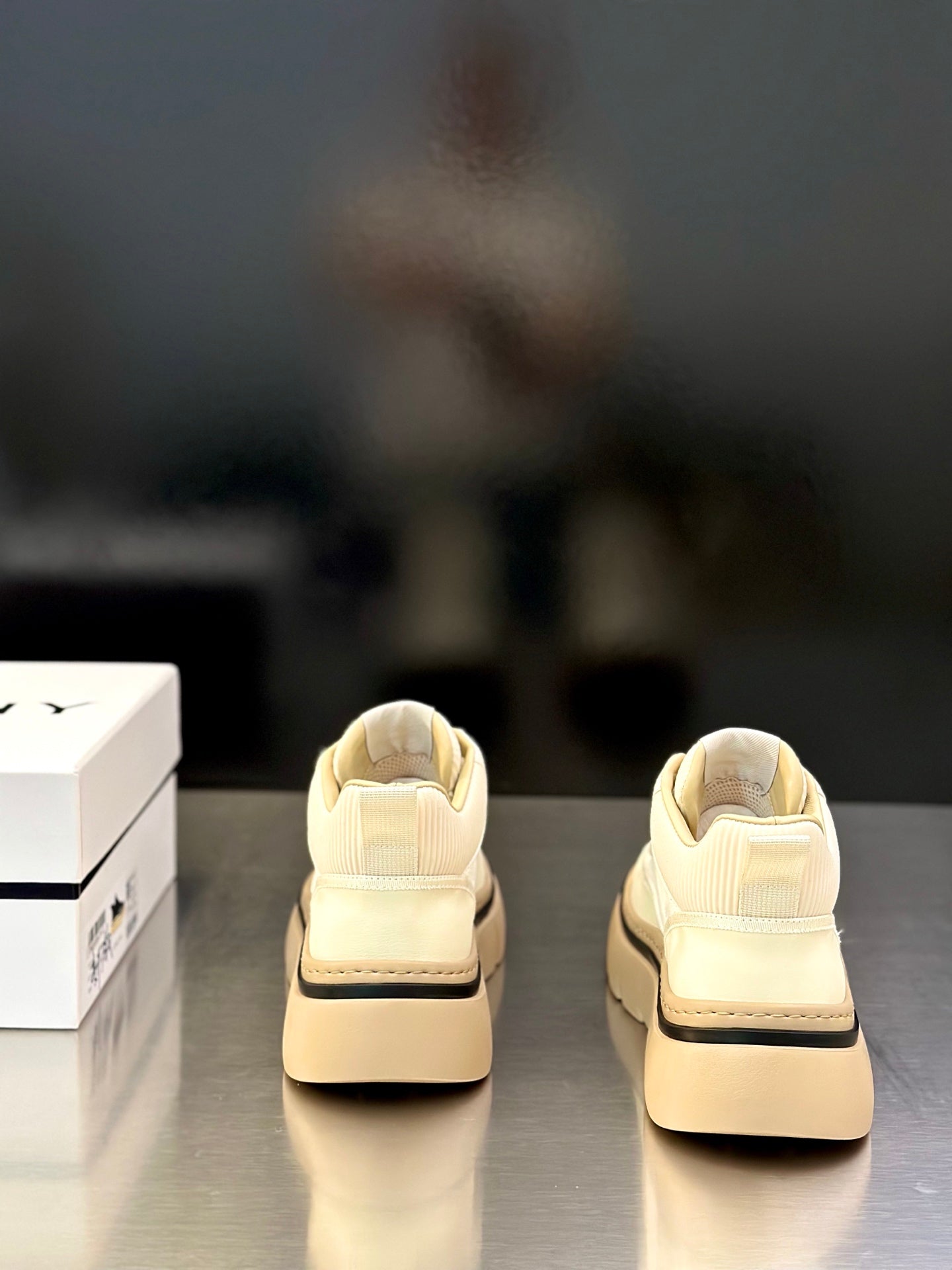 Givenchy cream sneakers shown from back, with heel logo detailing and platform sole