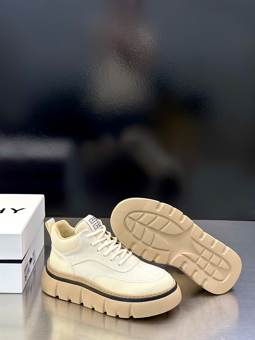 Givenchy cream sneaker pair with outsoles visible, tread pattern and lace-up upper