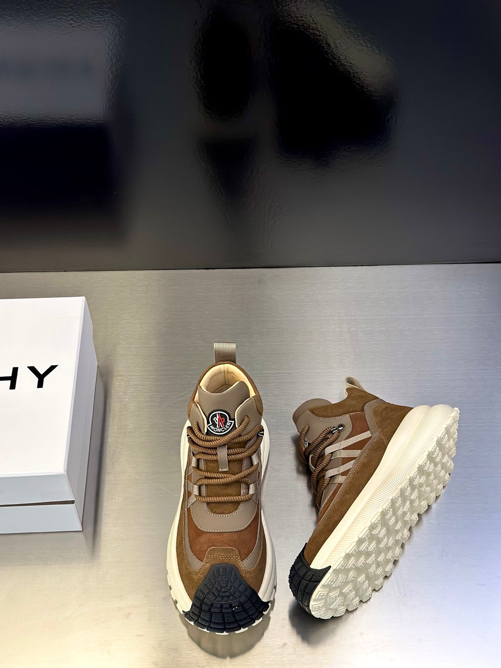 Moncler sneakers pair showing side view, tan and beige uppers with white tread sole