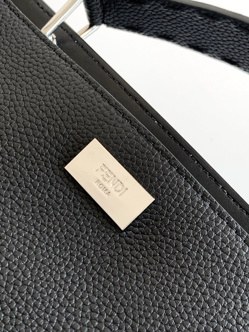 Fendi handbag leather close-up with embossed logo label on front