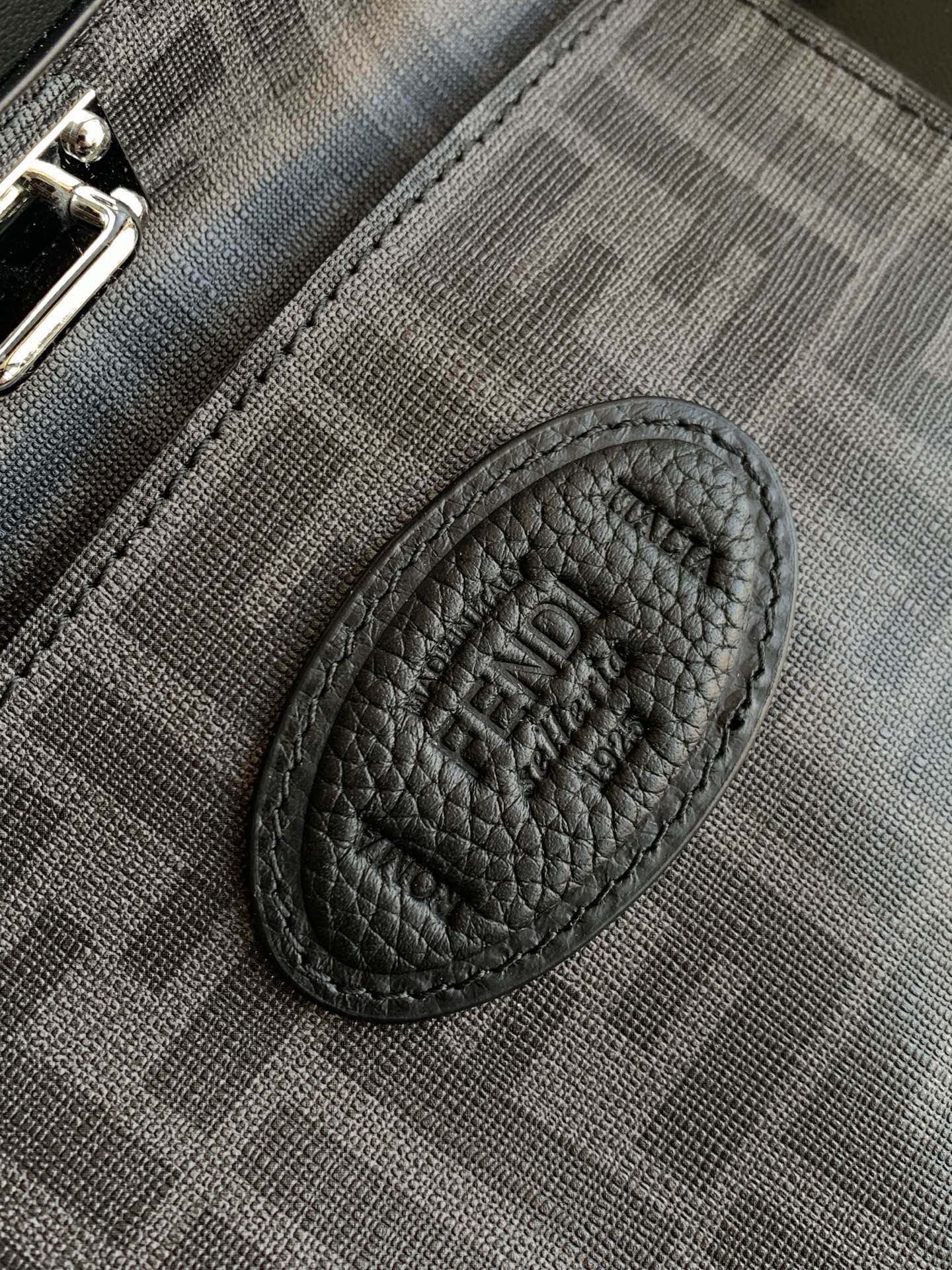 Fendi oval logo patch on textured interior pocket, black.