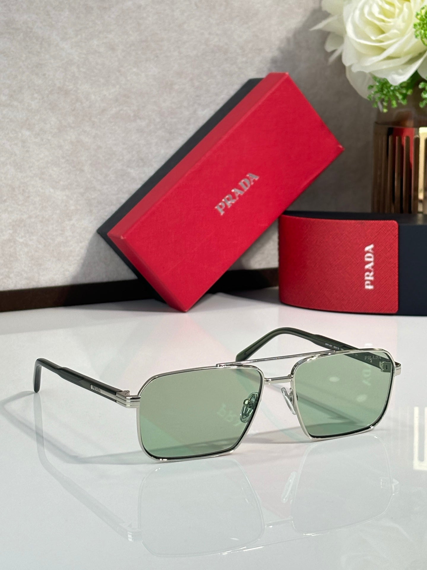 Prada square sunglasses with pale green lenses and metal frame