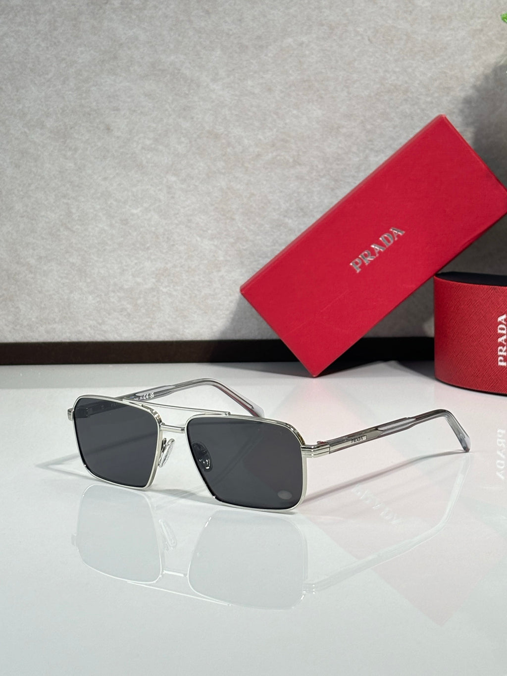 Prada square sunglasses with dark tinted lenses and silver metal frame