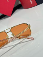 Prada amber tinted lens close-up with gold frame arms