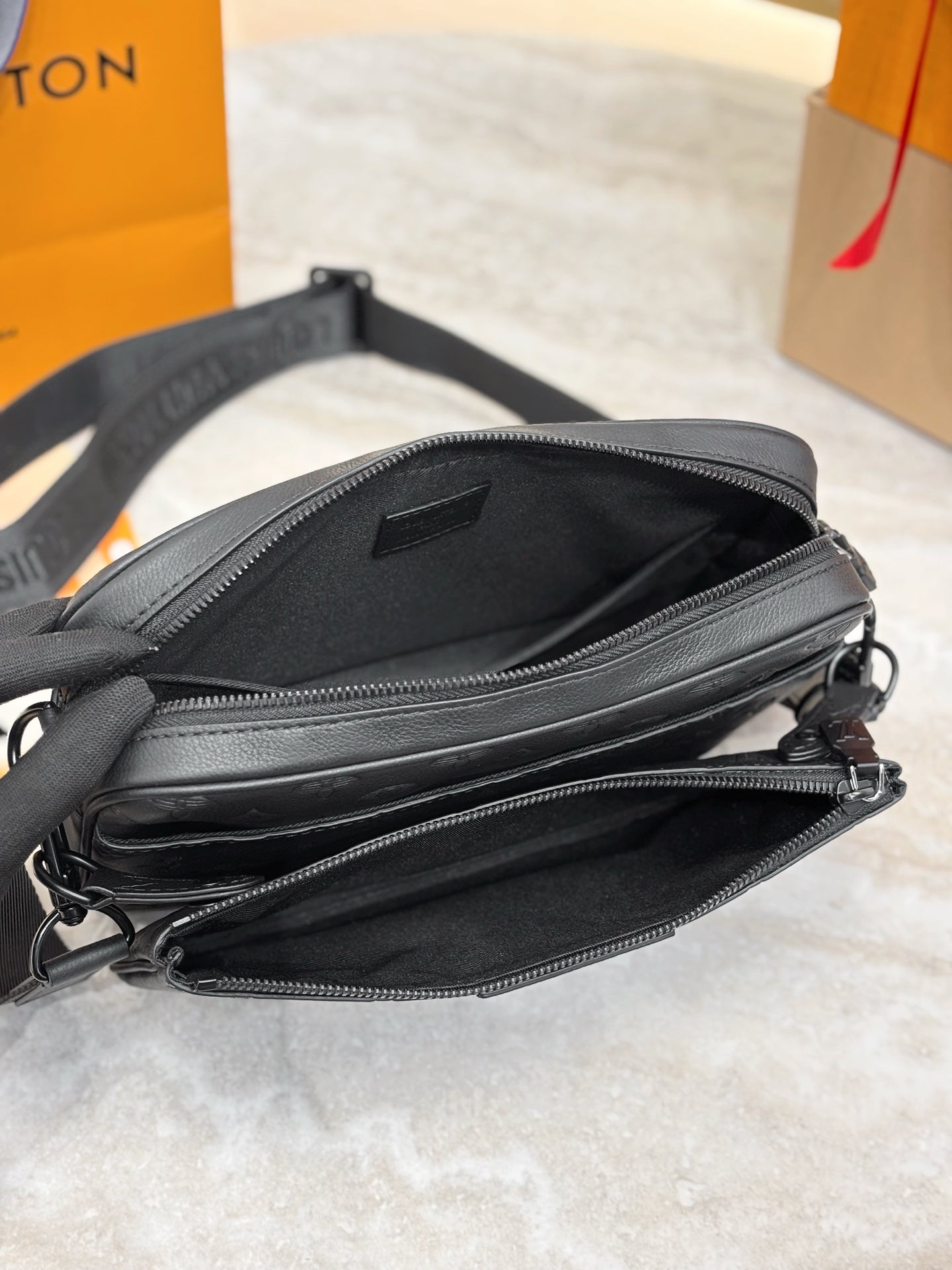 Louis Vuitton black monogram bag with open zip top, interior view and dual zipper tracks