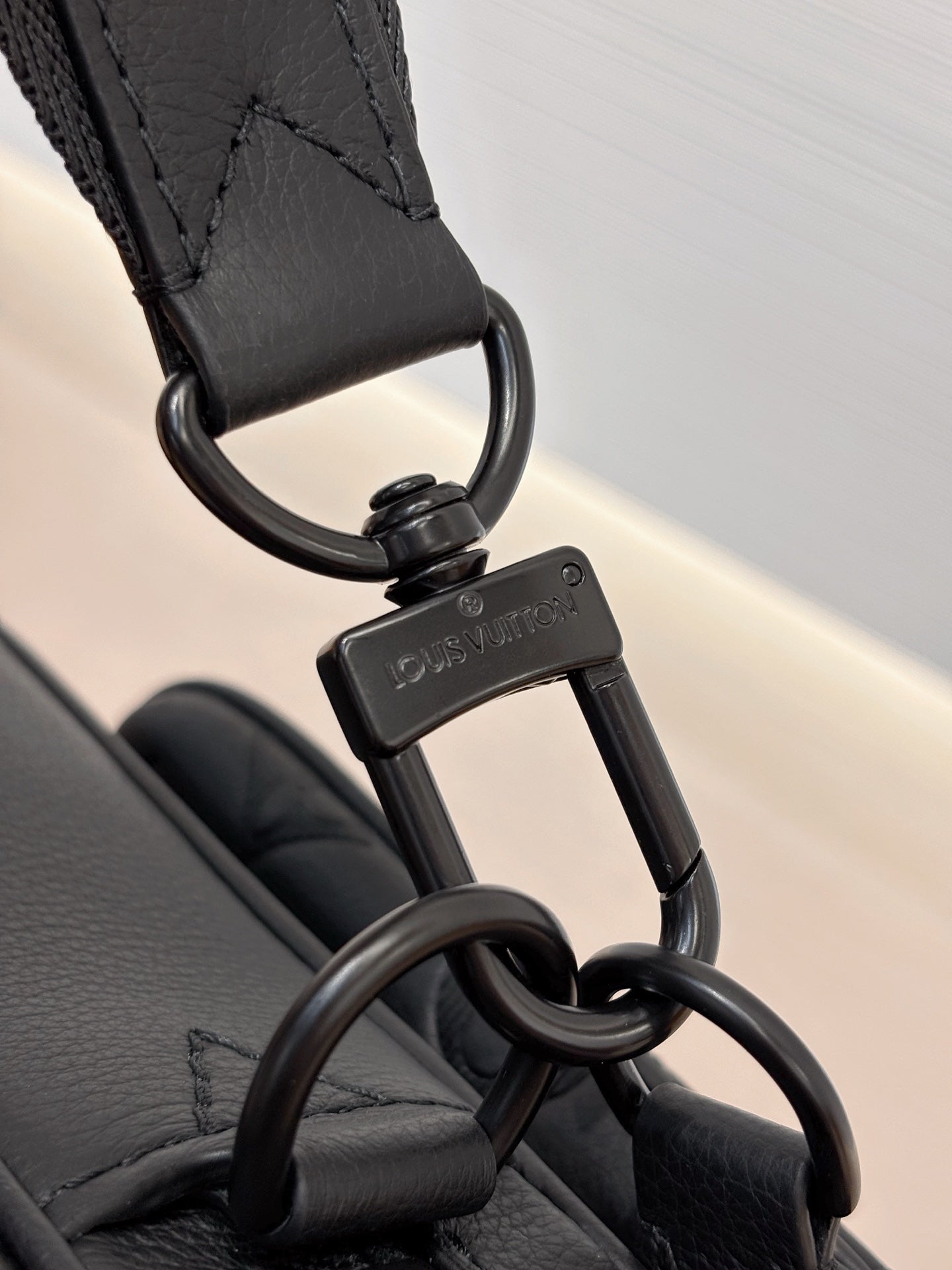 Louis Vuitton black monogram bag close-up of keyring clasp and attachment hardware