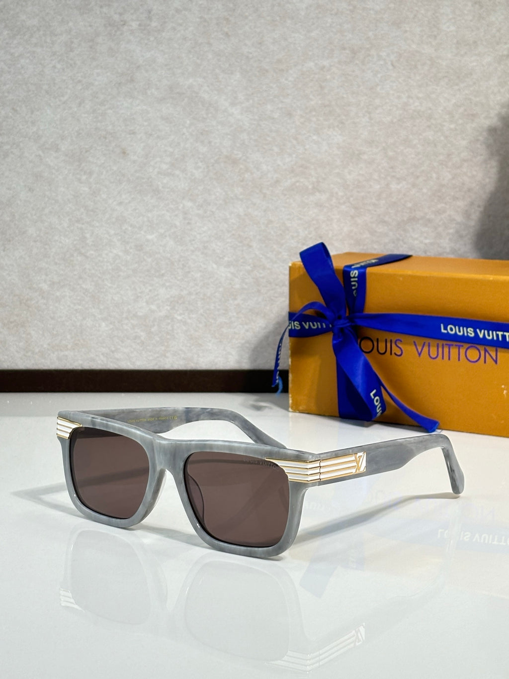 Silver rectangular eyeglasses with brown-tinted lenses and LV logo detail at the temple.