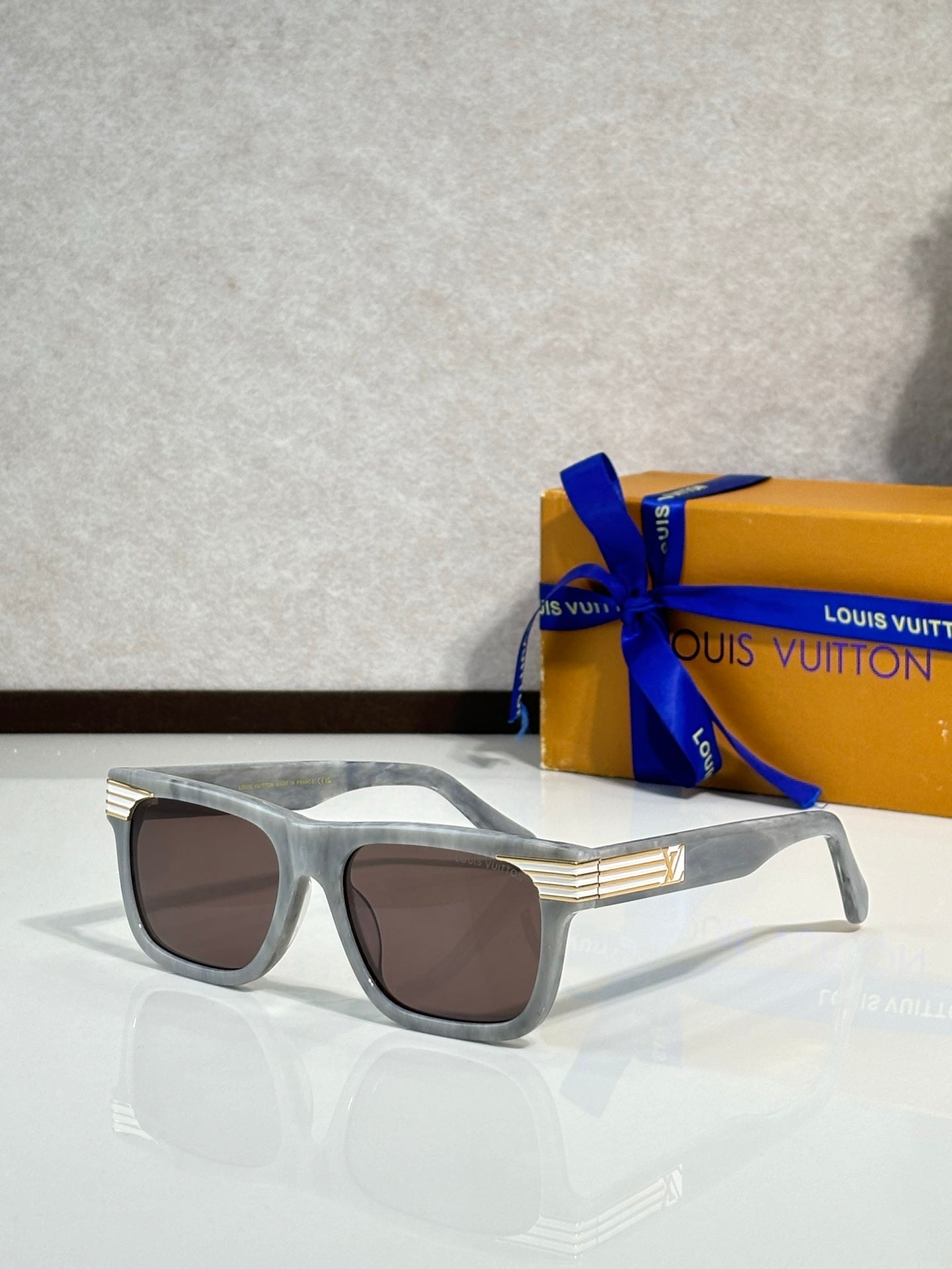 Silver rectangular eyeglasses with brown-tinted lenses and LV logo detail at the temple.