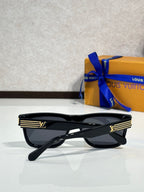 Black geometric eyeglasses with dark tinted lenses and LV logo striped temple detail.