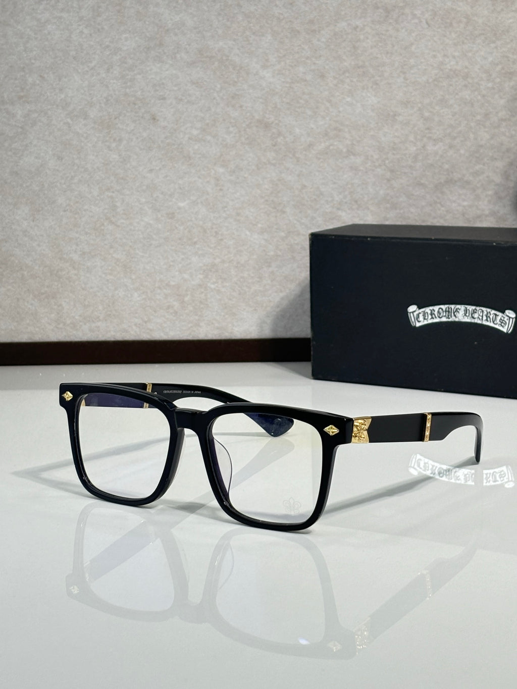 Black eyeglasses with dark blue lens tint and gold-tone bridge accents
