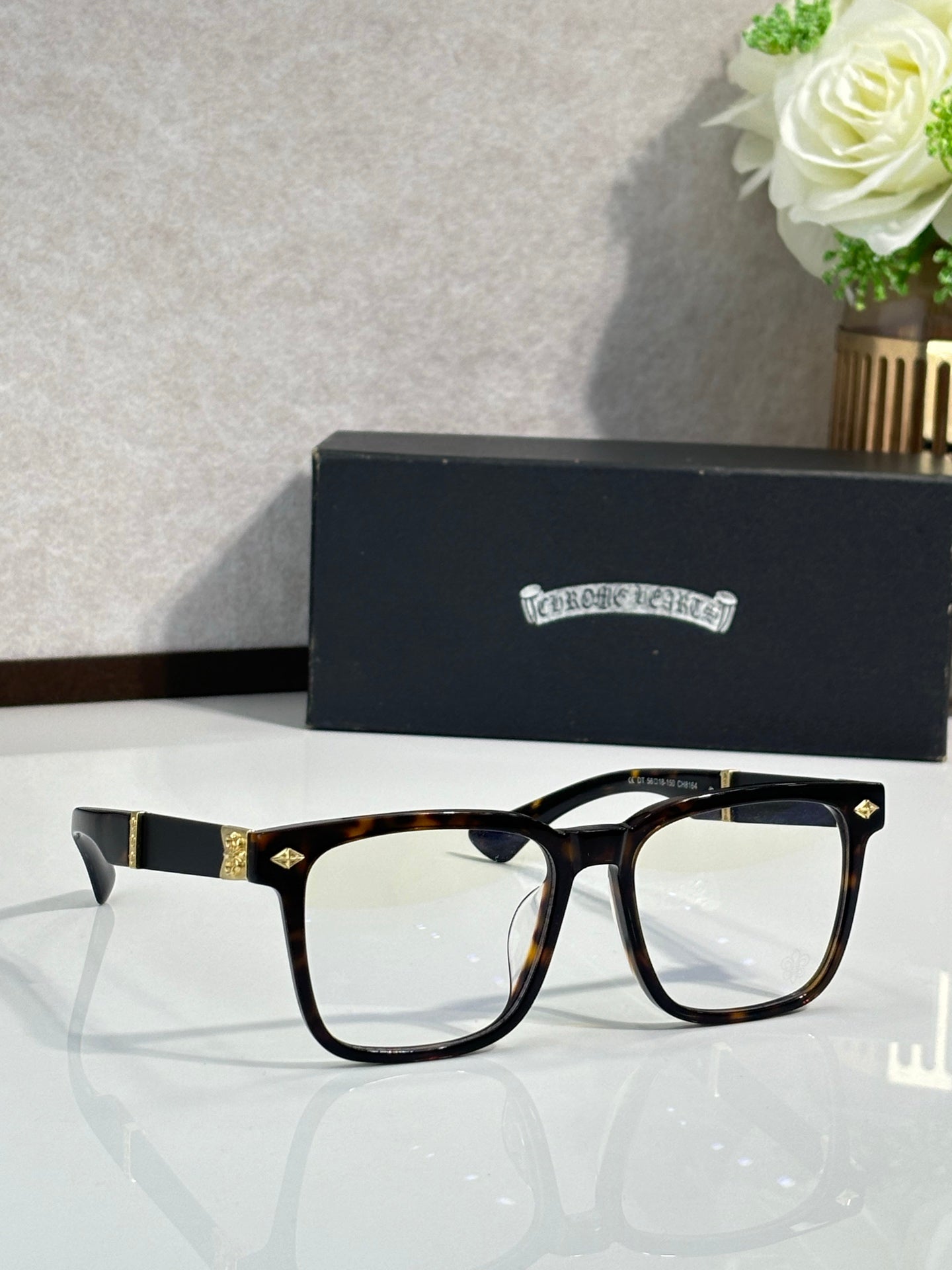 Tortoiseshell eyeglasses with clear lenses and gold-tone metal bridge