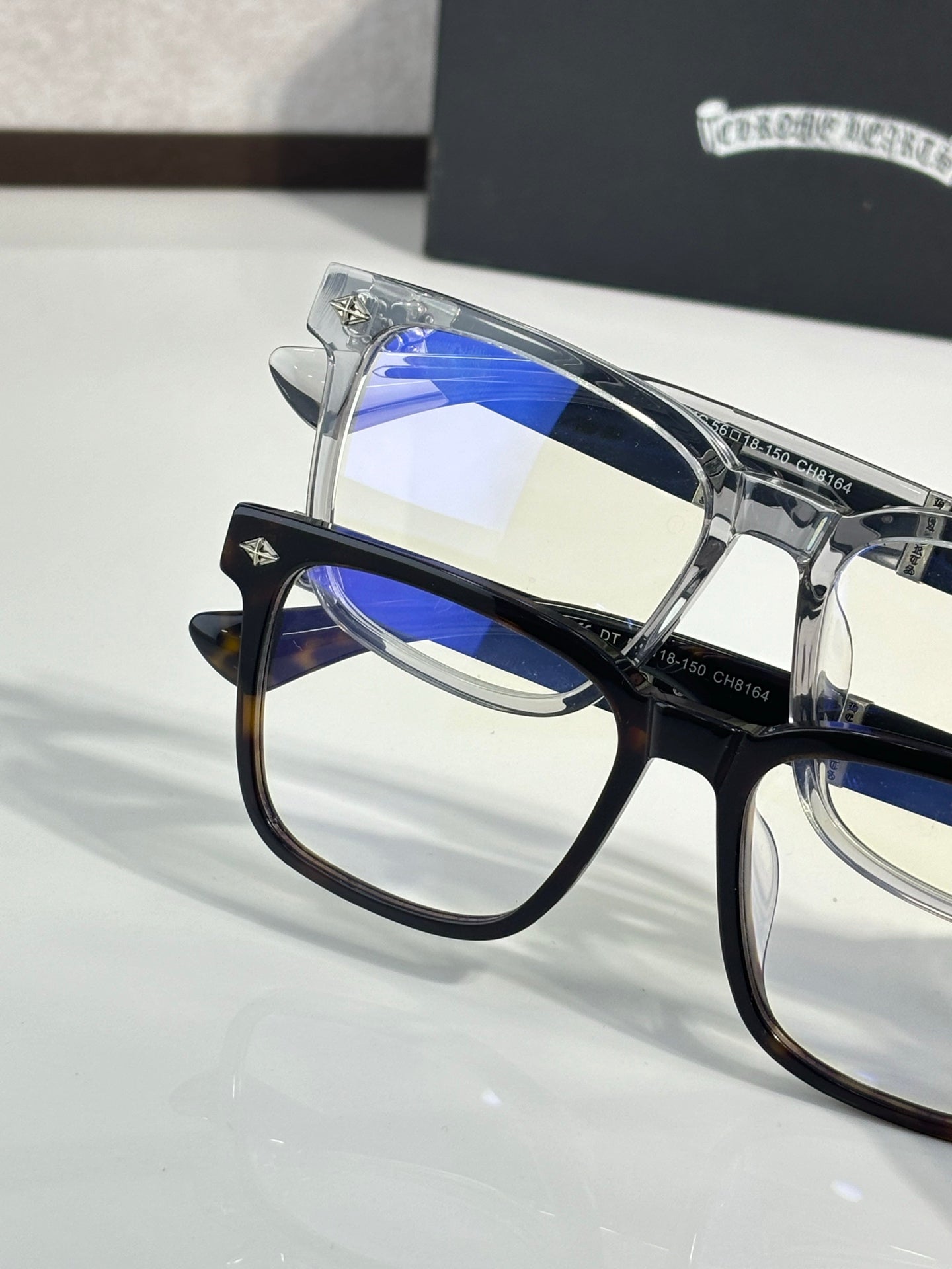 Blue-tinted lens eyeglasses with clear frame and reflective metal temples