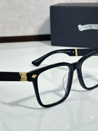 Black eyeglasses with blue lens tint and gold-tone side accents