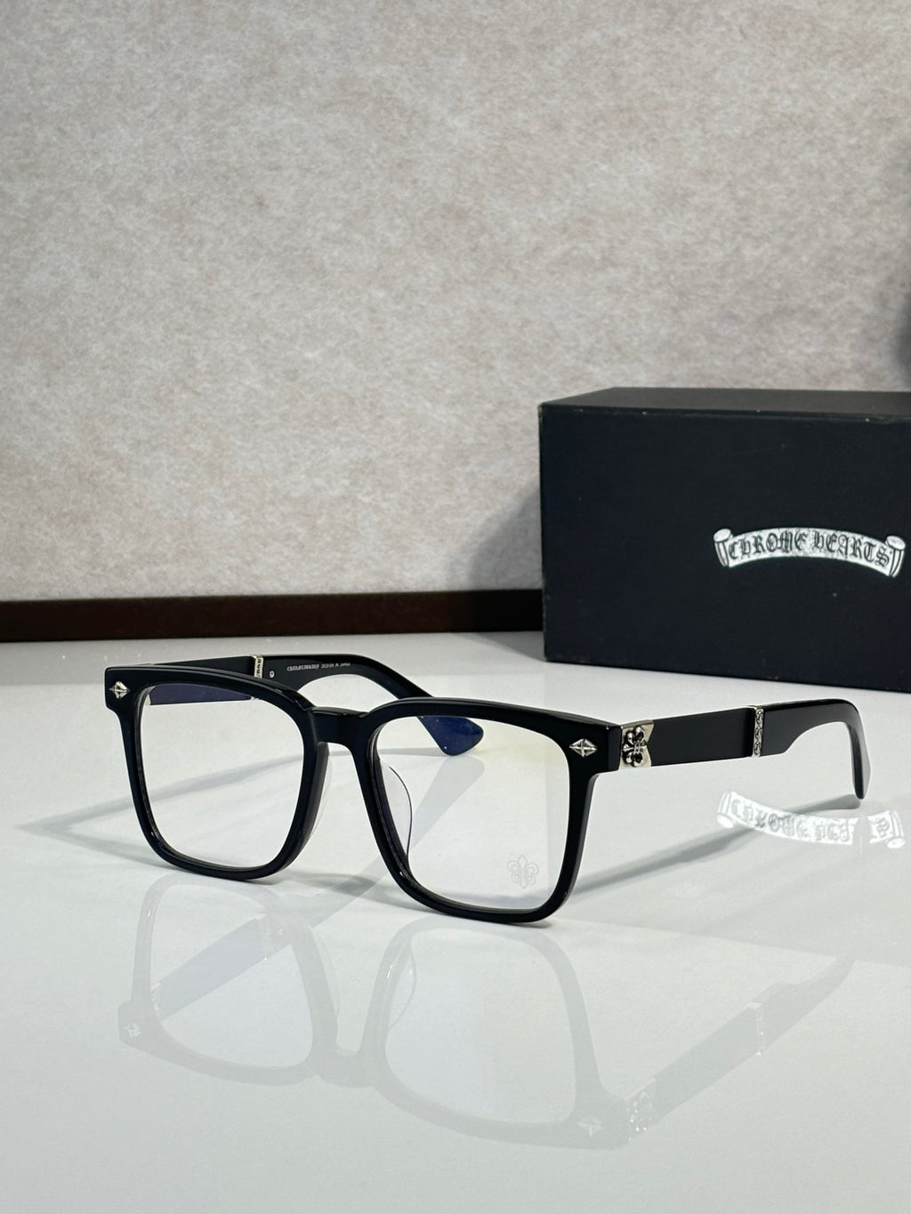 Black eyeglasses with blue-tinted lenses and gold-tone hinge details