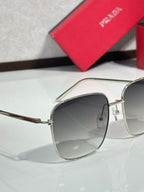 Prada sunglasses close-up with silver frame and dark gradient lenses, lens and frame detail