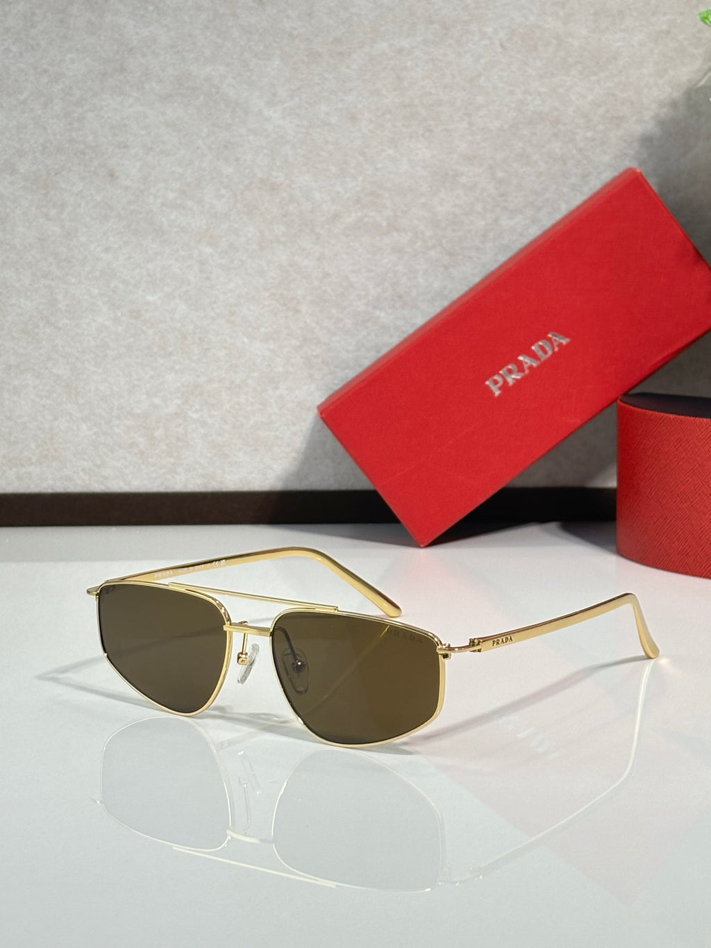 Prada aviator sunglasses with gold frame and brown tinted lenses