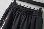 Balenciaga elastic-waist pants with side logo panel, black