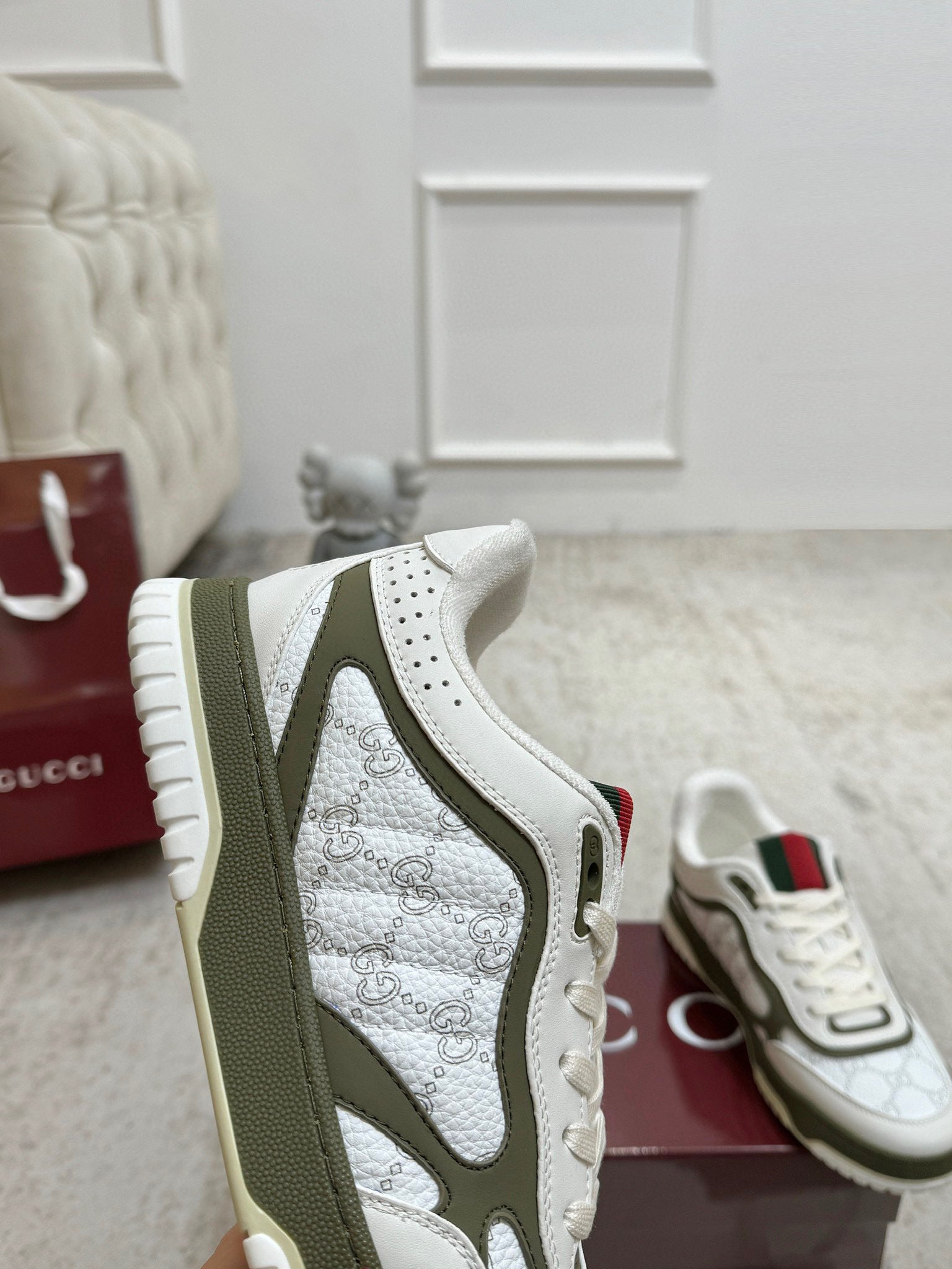 Gucci unisex sneakers close-up: white textured side panel with olive stripe and lace-up