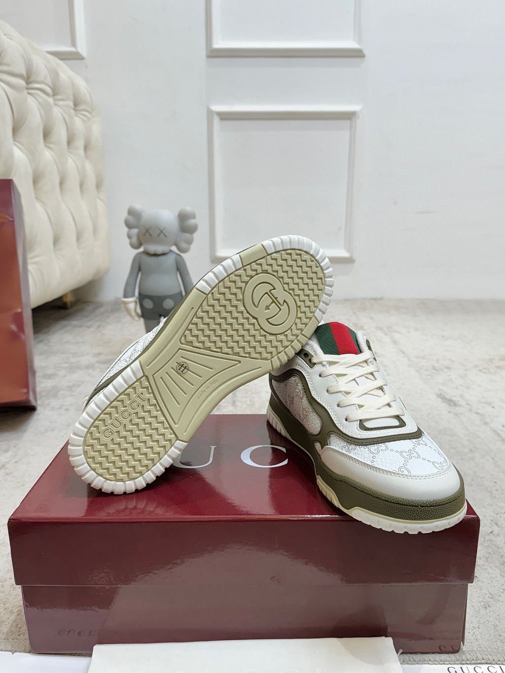 White and olive sneakers, outsole tread view, red collar stripe