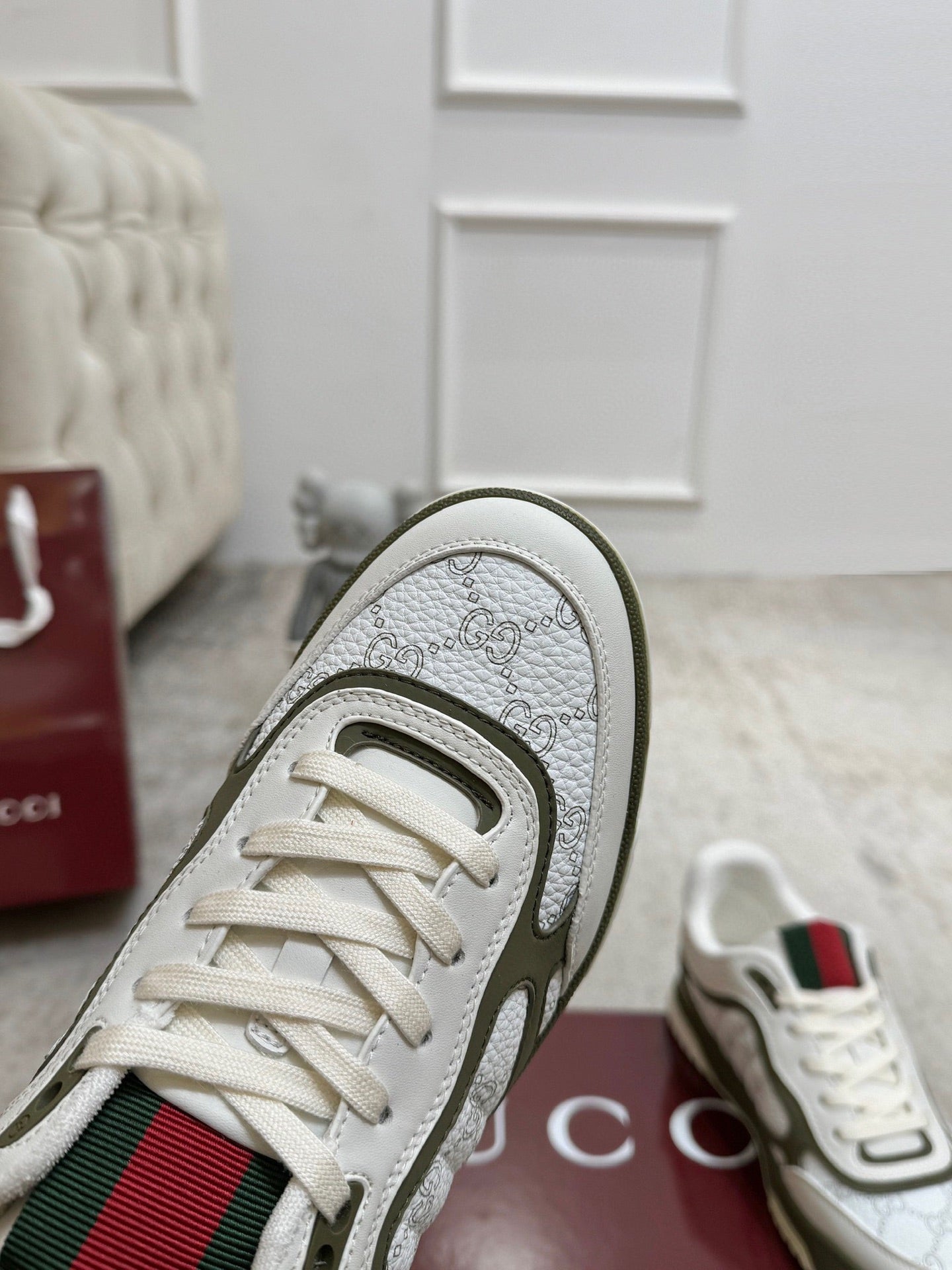 Gucci unisex sneaker close-up: white leather toe with olive trim and textured pattern