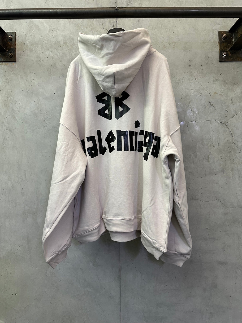 White long-sleeve hoodie with black Balenciaga logo graphic on the back