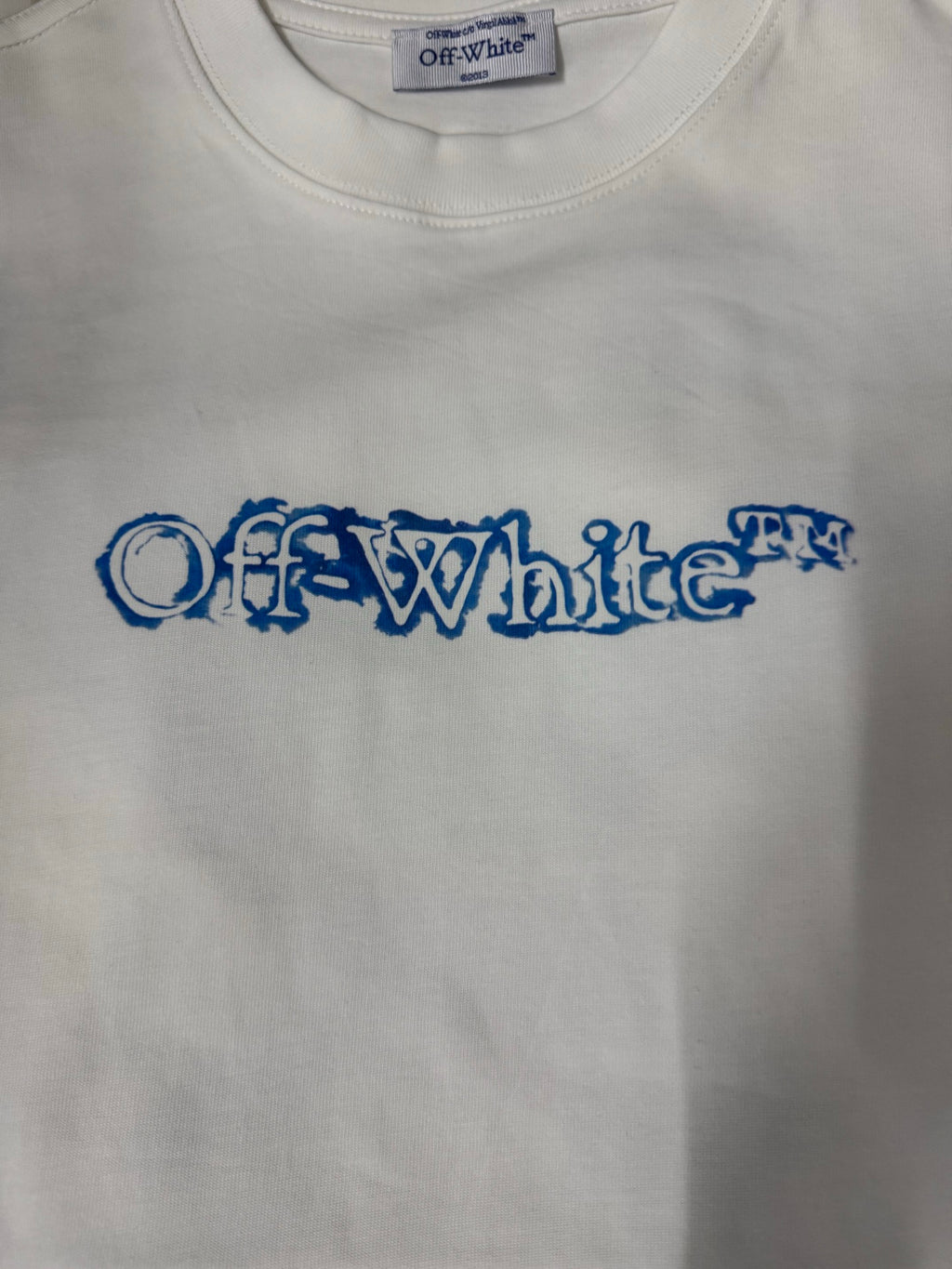 Off-White T-shirt close-up of blue logo text across the chest
