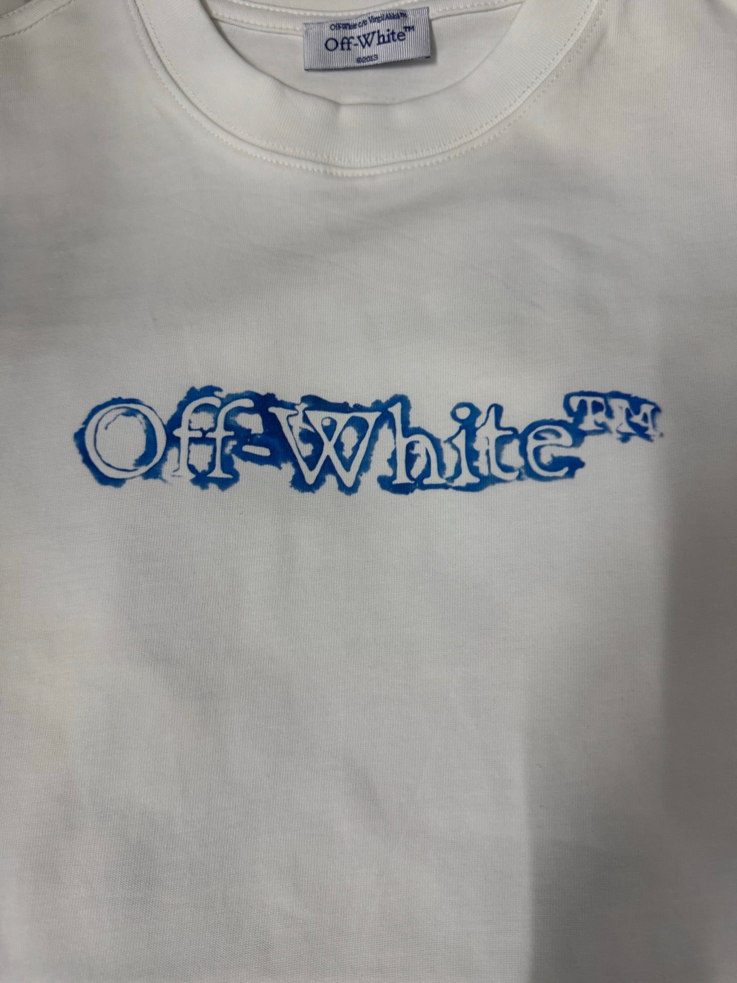 Off-White T-shirt close-up of blue logo text across the chest