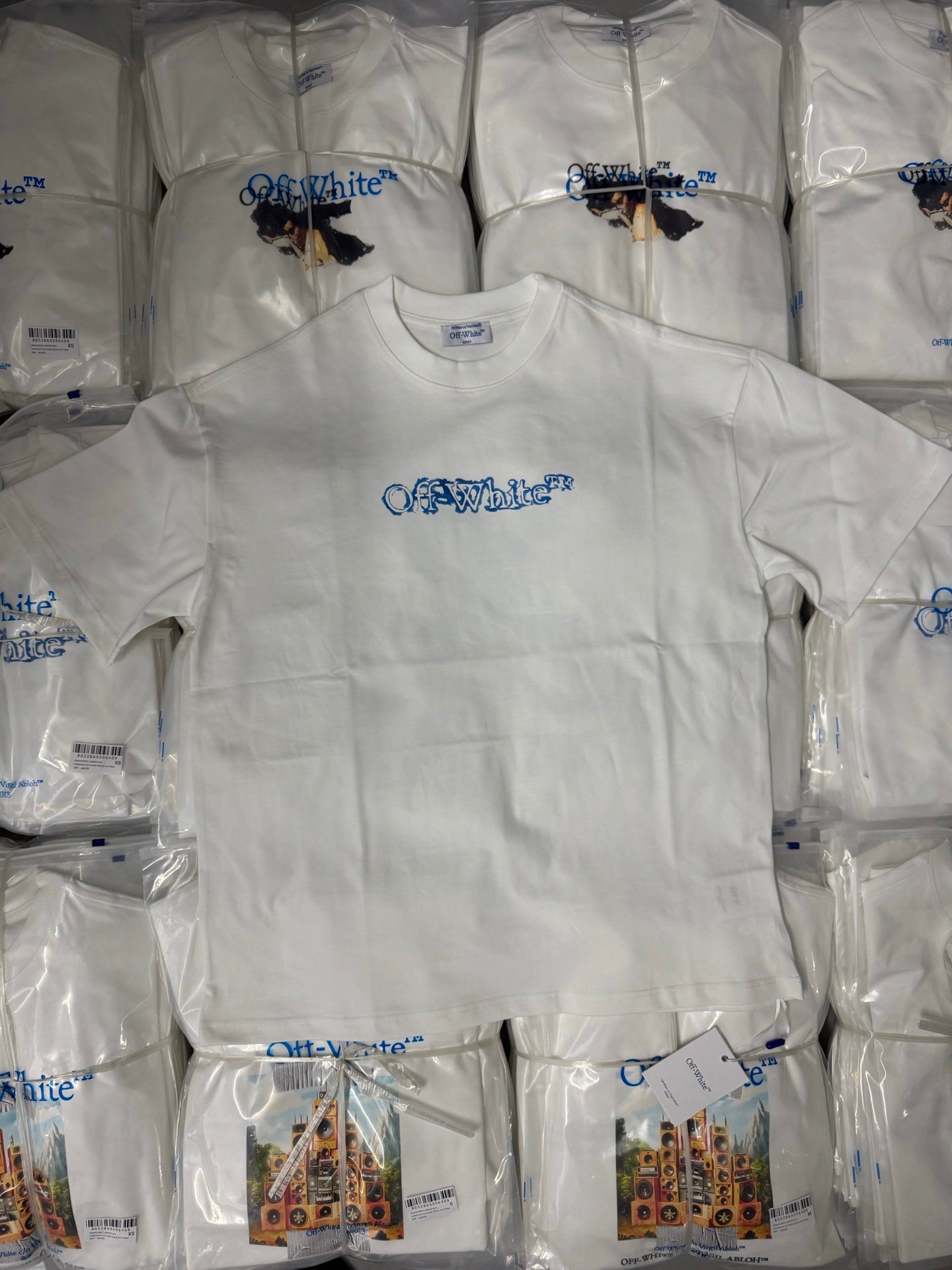 Off-White T-shirts, white with blue logo print on folded shirts in packaging