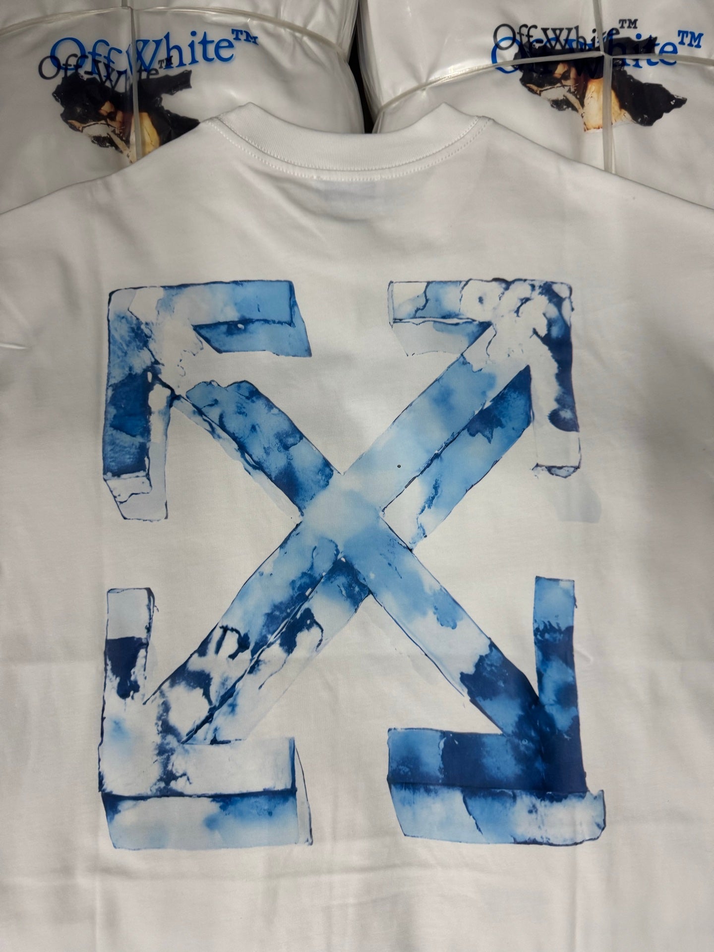 Off-White T-shirt featuring a large blue “X” logo graphic on the chest