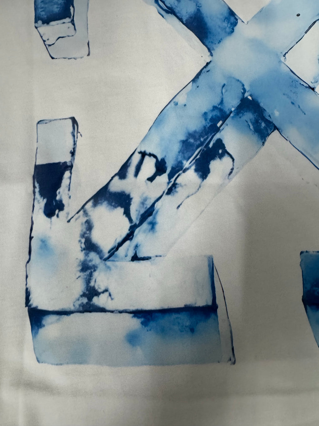 Off-White T-shirt close-up of blue “X” graphic and letter block shapes