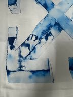 Off-White T-shirt close-up of blue “X” graphic and letter block shapes