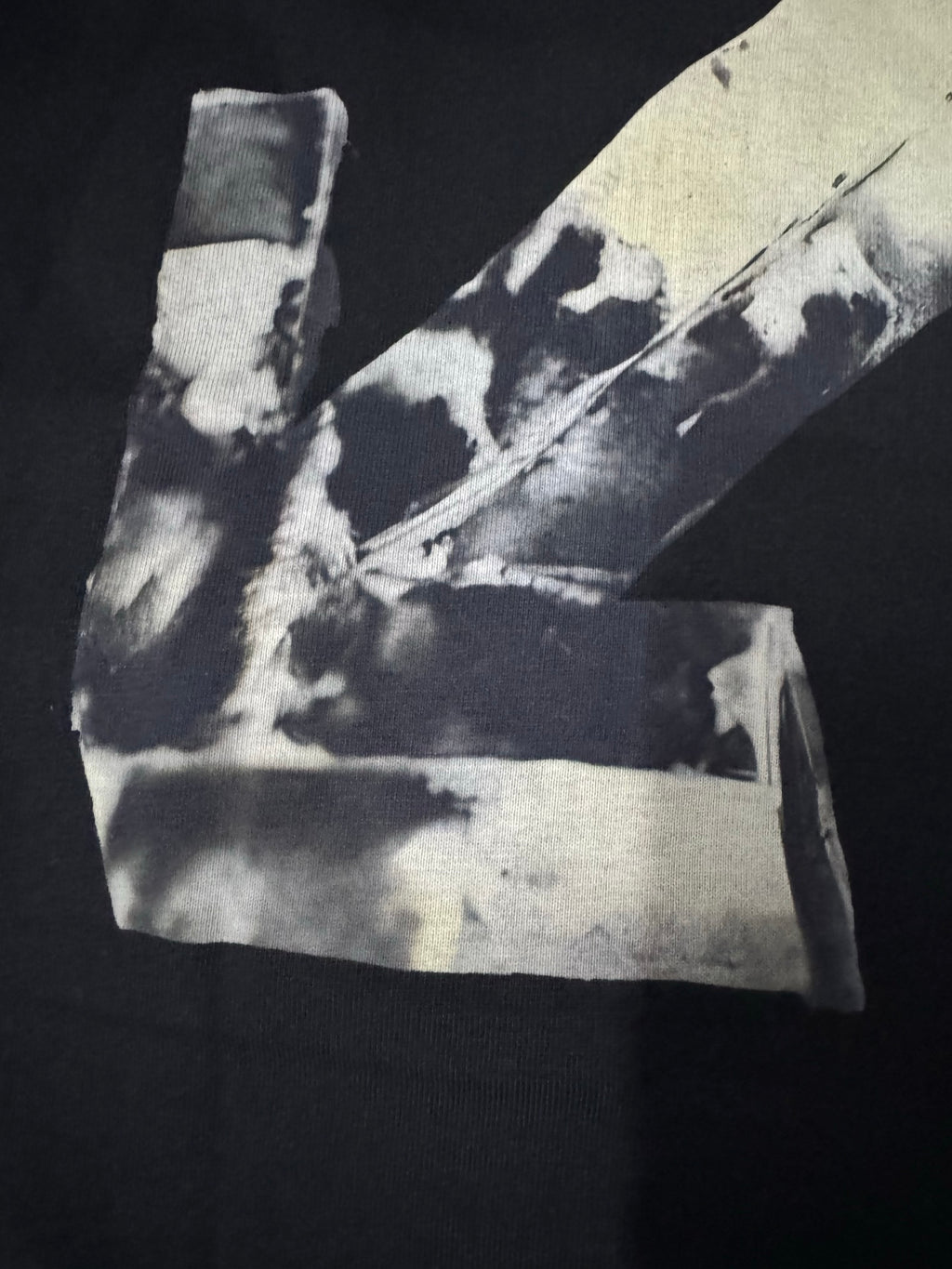 Black T-shirt close view: off-white Off-White X graphic at bottom