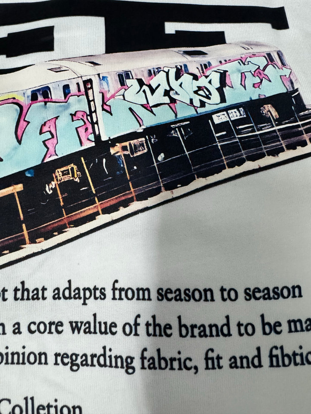 Off-White off-white T-shirt close-up with colorful train graphic and surrounding text