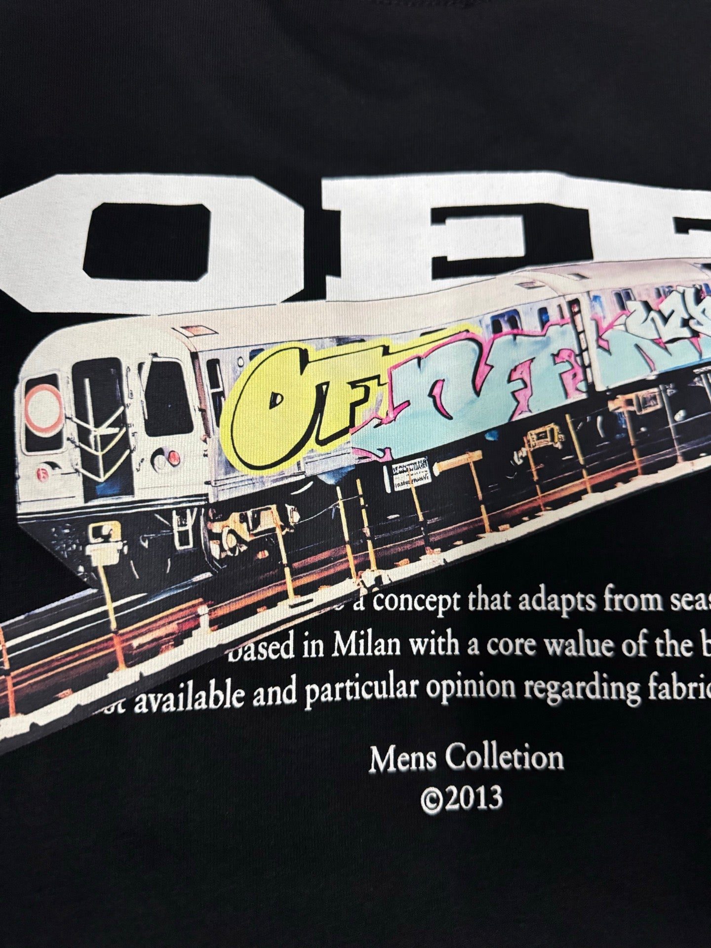 Black T-shirt close-up of bus graphic with colorful graffiti and white text