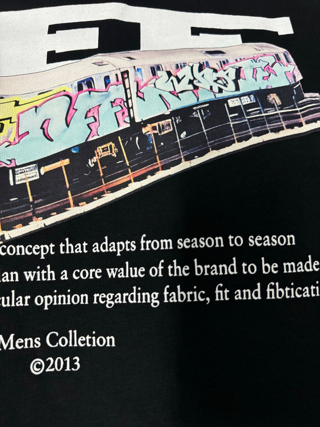 Off-White dark T-shirt close-up of vehicle graphic with Mens Collection text