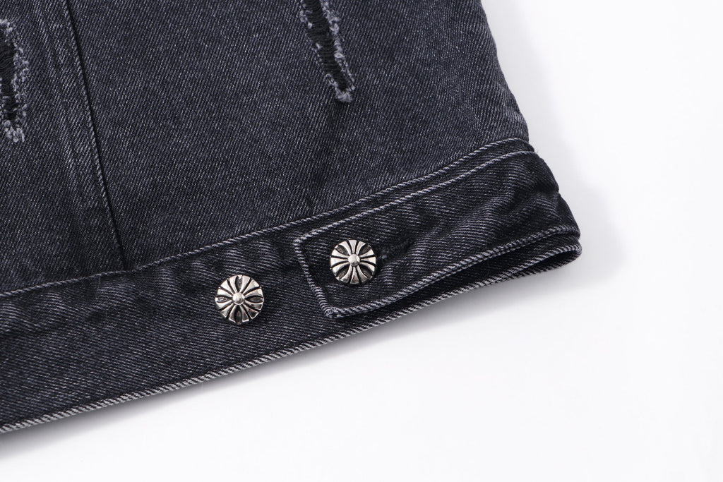Dark denim jacket hem with decorative snap stud buttons and embroidered motifs