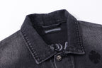 Dark denim jacket collar with snap buttons and small embroidered emblem