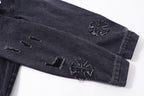 Dark denim jacket sleeve with embroidered star-like motifs near cuff
