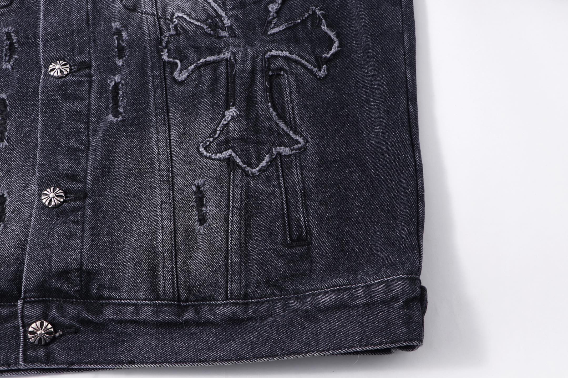 Dark denim jacket chest detail with embroidered cross and stitched panels