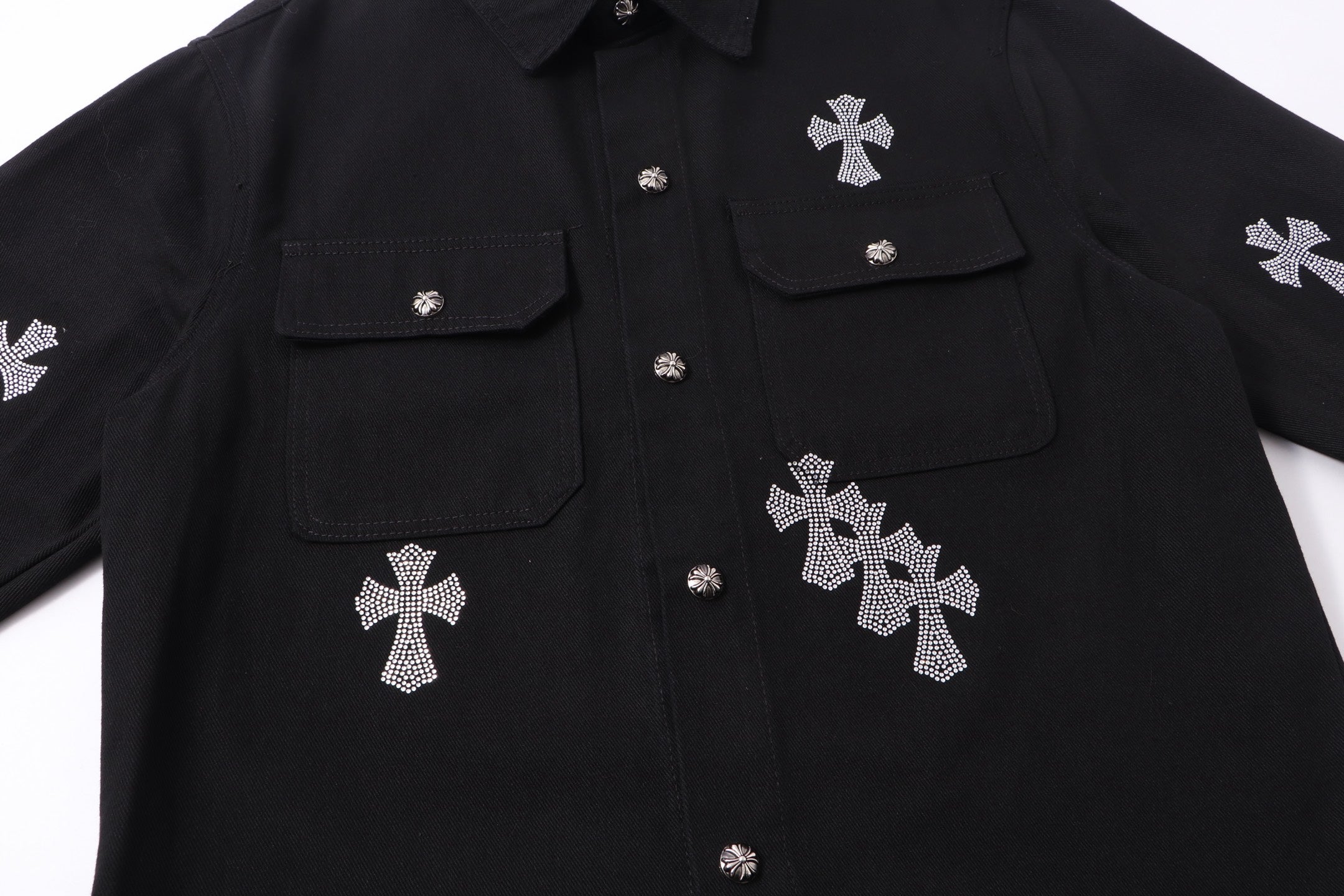 Black overshirt with snap buttons, flap pockets, and rhinestone cross motifs