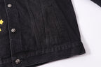 Black denim-style jacket hem with silver buttons and stitch detailing