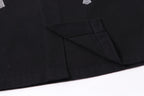 Black button-up shirt jacket hem with angled seam detail