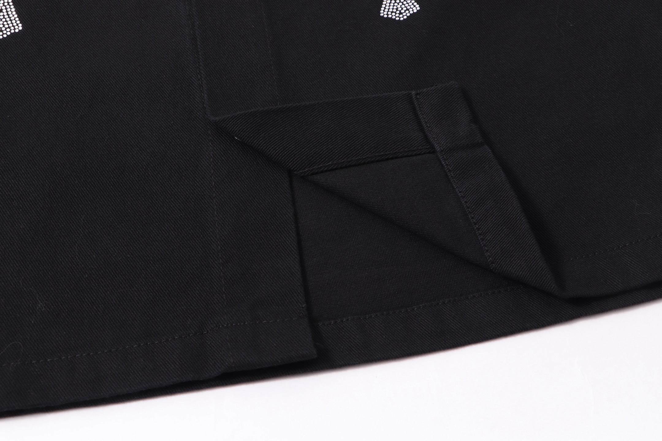 Black button-up shirt jacket hem with angled seam detail