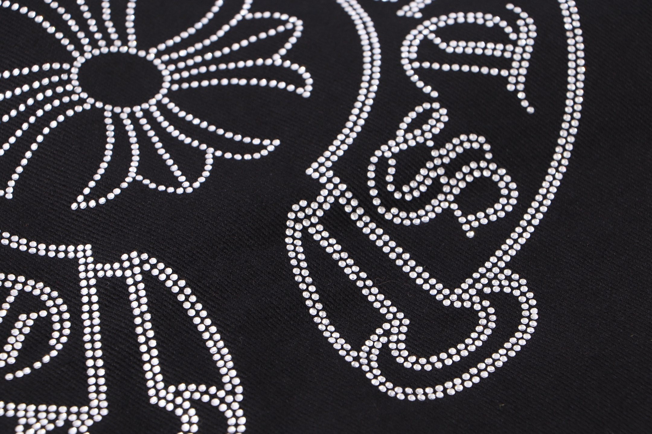 Black fabric with white rhinestone swirl and star cross decoration