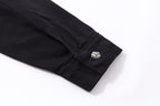 Black shirt sleeve cuff close-up with decorative button detail.