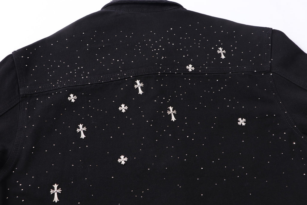 Back yoke close-up with white star and cross motifs across black shirt.