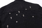 Back yoke close-up with white star and cross motifs across black shirt.