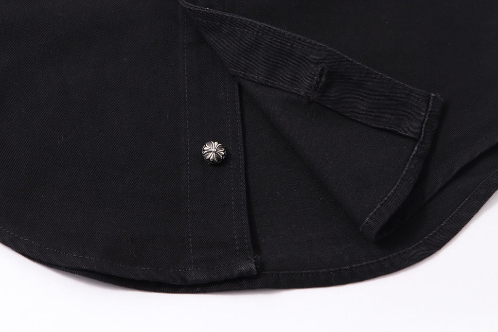 Black shirt hem with button and curved cuff seam detail.