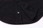 Black shirt hem with button and curved cuff seam detail.