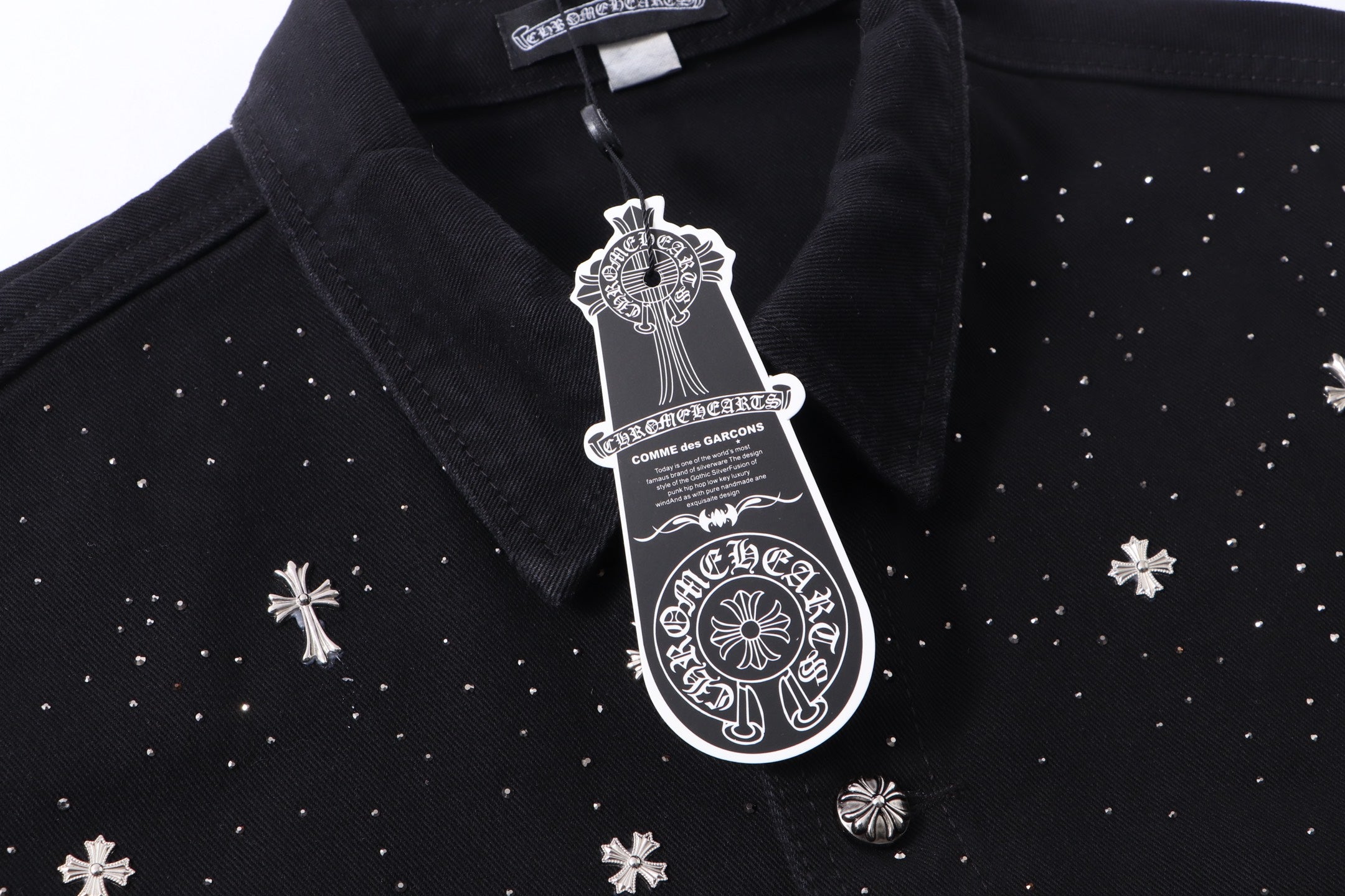 Black shirt collar with white emblem patch and button placket detail.
